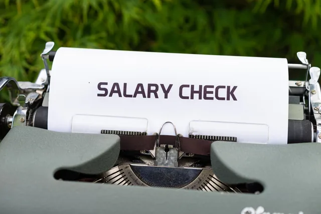 Close-up of a vintage typewriter typing 'Salary Check' on paper, symbolizing payroll and finance. Payroll software in England: what PAYE, pension duties and UK business counts show a supplier